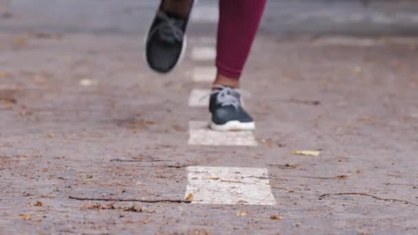 Pernas fechadas de mulher étnica corredora de tênis. Africano preto feminino treinador de fitness pára dobra-se para amarrar cadarços em tênis de corrida. Esporte, estilo de vida ativo jogging ao ar livre conceito de promoção — Vídeo de Stock