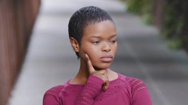 Düşünceli Afrikalı Amerikalı genç siyahi kadın sporcunun portresi. Teklifi düşünen, seçim yapan fitness eğitmeni. Milenyum melez kızı kameraya bakıp reddediyor, jest yapıyor hayır, katılmıyorum.