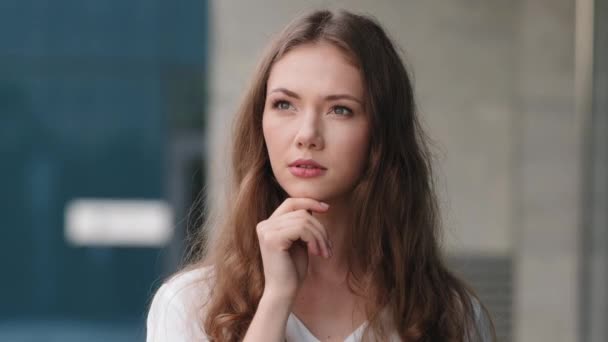 Portrait de femme en plein air caucasien millénaire belle fille coûteuse perplexe embarrassé femme modèle étudiant femme debout en plein air tenant son menton penser profondément dans la prise de décision des plans de pensée — Video