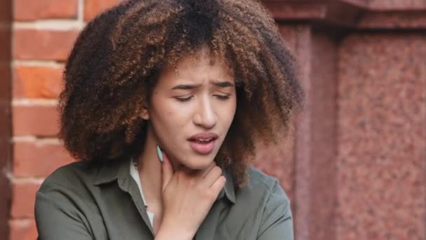 Närbild afroamerikansk svart kvinna känns ohälsosam och hosta berör halsen, lider av smärta i halsen. Pneumoni, covid symptom, behöver medicinsk behandling, feber, med första influensa grippe koncept — Stockvideo
