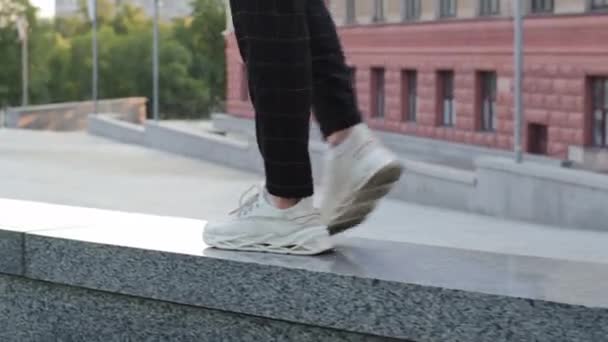 Jambes masculines en baskets blanches qui courent sur le trottoir de granit de pierre, gros plan. Homme joyeux marche seul en ville, gars satisfait revient après une date réussie ou réunion d'affaires, bonne humeur, concept de légèreté — Video