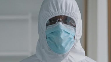 Afrikalı doktor doktor portresi. Bilim adamı. Koruyucu giysi maskesi takıyor. Gözlük de kameraya bakıyor.