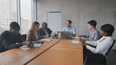 Çok ırklı iş adamları grubu ortakları çeşitli iş arkadaşları toplantı brifinginde oturup İspanyol Arap adam lideri patron akıl hocalığı eğitimini dinlerler.