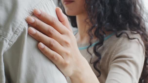 Zbliżenie kobieca ręka z naturalnym manicure leży na męskim objęciu ramienia. Nierozpoznawalne kręcone dziewczyna kobieta żona trzymając rękę ukochanego męża partner mężczyzna noszenie koszuli małżeństwo przytulanie w domu — Wideo stockowe