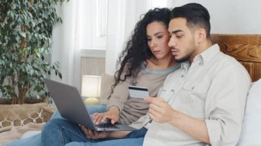 İspanyol Arap evli çift milenyum karı koca ve koca sevgili tüketiciler internet üzerinden alışveriş yapmak için dizüstü bilgisayar kullanıyorlar banka kartından giriş numarası