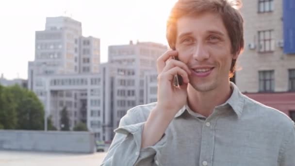 Χαμογελώντας millennial άνθρωπος μιλάμε chat στο τηλέφωνο, νεαρός Euphoric ευτυχισμένη αρσενικό εκτελεστικό διευθυντή των εργαζομένων μιλώντας απολαμβάνοντας ευχάριστη συνομιλία με φίλο ή φίλη, κάνοντας κλήση από το τηλέφωνο — Αρχείο Βίντεο