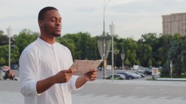 Yabancı erkek turist uluslararası öğrenci Afrikalı Amerikalı adam Afrikalı gezgini kaybetti. Sokakta duruyor, haritayla yol güzergahını araştırıyor.