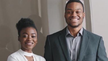 Gülümseyen mutlu Afro-Amerikan iş adamı ve iş kadını profesyonel yöneticiler kameraya bakıyor. Mutlu kendine güvenen karışık ırk şirket lideri kadın patron ya da stajyer portresi