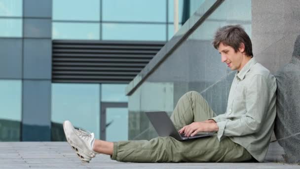 Millennial guy quickly energetically typing article, report or message on laptop keyboard, young adult man satisfied with seminal, successful productive work, smiles, raises thumb up, shows ok gesture — Stock Video