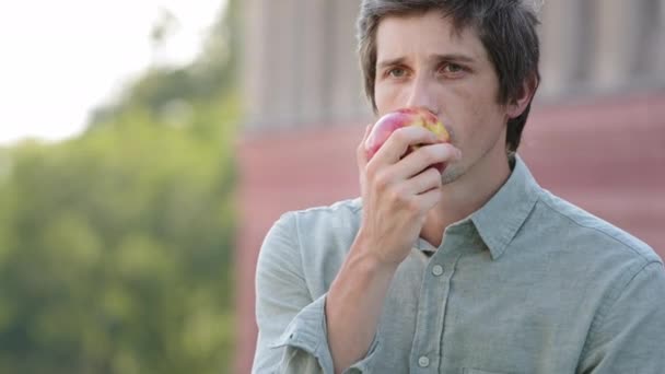 現代の製品無臭で無味。ミレニアル世代の男は果物と朝食をしたいと思っていますが、熟してジューシーな新鮮なリンゴは香りがしません。心配な男は匂いの感覚をテストする — ストック動画