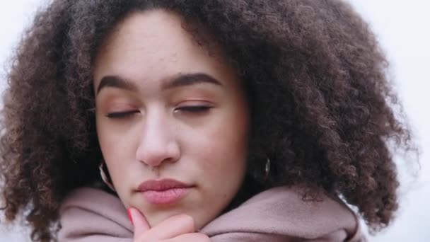 Zbliżenie zamyślonej kobiecej twarzy, kręcone włosy nieufna poważna Afroamerykanka z lokami stoi na dworze, myśląc, że masuje podbródek dłonią, rozwiązuje problem — Wideo stockowe