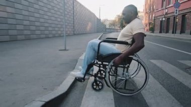 Yaşlı siyahi Afrikalı engelli insan karşıdan karşıya geçer ve kaldırıma tırmanmaya çalışır. Tekerlekli sandalyedeki olgun adam şehrin sokaklarında dolaşmakta zorlanıyor. Erişilebilir çevre kavramı