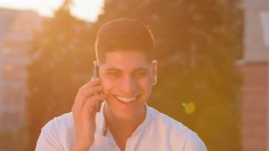 Gülümseyen mutlu Hintli Arap adam etnik erkek serbest çalışan işadamı cep telefonuyla konuşuyor. Ortadoğulu kendinden emin bir adam dışarıda bekleyen çağrıya cevap veriyor.