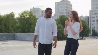 Çok ırklı ilişkileri olan genç, çok ırklı çift arkadaşlar, iş arkadaşları, Afrikalı Amerikalı erkek ve Kafkasyalı kadın, şehir sokaklarında yürüyor ve boks jestleri hakkında konuşuyorlar.