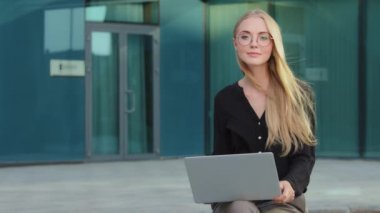 Kafkas Avrupalı sarışın, dışarıda dizüstü bilgisayarla gülümseyen mutlu, çekici iş kadını başarılı bir serbest girişimci ya da kameraya bakan genç kız öğrenci.