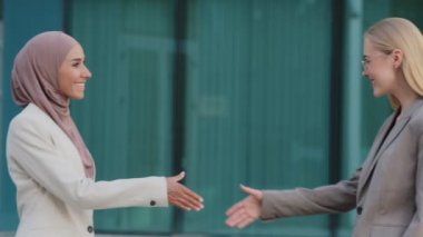Binlerce yıllık tesettürlü Hintli kadın ve Avrupalı genç iş kadını tanıştığımıza sevinerek el sıkışarak birbirlerini selamlıyorlar. Arkadaş canlısı asker ya da yönetici yeni iş arkadaşıyla tokalaşıyor
