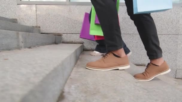 Dva páry nohy mužské a ženské nohy v módní obuvi chůze kroky ve městě v obchodě nákupní centrum nést světlé nákupy tašky, nepoznatelní kupující zákazníci chůze stepping, prodejní slevy — Stock video