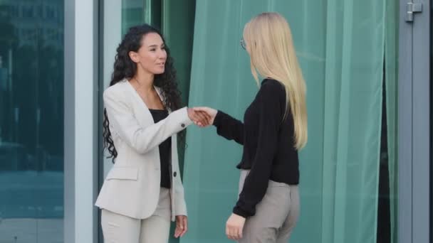 Amistosa sonrisa milenaria diversas colegas femeninos saludándose entre sí por apretón de manos. Reclutador sacudiendo la mano exitosa empresaria india en la reunión, gerente haciendo mucho con el cliente — Vídeo de stock