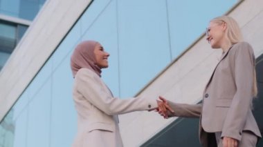 Mutlu Müslüman iş kadını tesettür satış müdürü bin yıllık beyaz kadın müşteriyle çeşitli kadın ortaklığı, saygı ve işbirliği konseptinde anlaşma yapıyor.