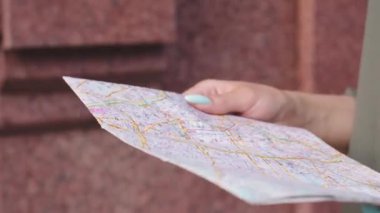 Seyahat rehberini tutan kadınların yakın görüntüsü. Genç siyahi kadın turist güneşli bir yaz gününde kaldırımda tek başına yürüyordu. Gezmek için rehber kitabı kullanıyordu. Seyahat kavramı