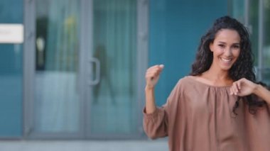 Kıvırcık esmer, uzun saçlı, stil sahibi kadın dansçı sokak dönüşlerinde aktif olarak müzik eşliğinde dans ediyor. Dönüşler yapıyor, el hareketleriyle dans ediyor.
