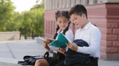 İki hippi çocuk öğrenci ders sonrası kitap okuyarak dışarıda oturuyorlar. Kız kitap okuyor, üzgün çocuk günlükte kötü not gösteriyor, defter hata hakkında konuşuyor, okula geri dönüyor.
