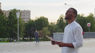 Yalnız Afro-Amerikan adam Afrikalı melez ırkçı zenci erkek turist New York 'ta açık havada durup kağıt haritaya bakarak işaret parmağıyla yön noktalarını araştırıyor.