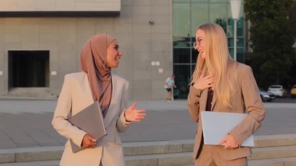 Las empresarias indias en hijab y las jóvenes europeas en ropa formal que finalizan las negociaciones se despiden al aire libre con apretón de manos. Compañeras confiadas estrechando las manos confirman acuerdo — Vídeos de Stock