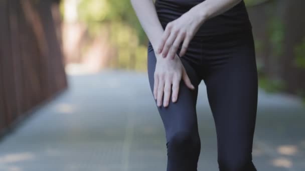 Close-up pernas femininas em leggings pretos de irreconhecível esbelta ativa mulher forte corredor correndo corrida de manhã treinamento pára de sentir dor no joelho dor sofre de danos problemas articulares lesão — Vídeo de Stock