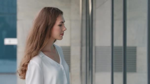Töprengő fiatal gyönyörű kaukázusi nő Y-generációs lány vásárló nő fogyasztó áll a városban a szabadban, közel bolt ablak épület kirakat nézett áruk ruhák teszi vásárlási választás — Stock videók