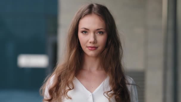 Gros plan portrait avant de jeune femme blanche beauté millénaire avec des cheveux longs femme d'affaires fille debout sur la rue à l'extérieur regardant amical à la caméra. Visage humain parfait maquillage naturel peau — Video