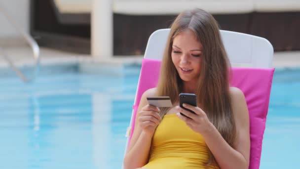 Mujer joven feliz en traje de baño con tarjeta de crédito utilizando pagos móviles instantáneos. Sonriendo hermosa chica cliente comprador haciendo compra en el teléfono inteligente recibiendo concepto de devolución de dinero. Servicio de aplicaciones de banca electrónica — Vídeos de Stock