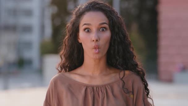 Closeup funny hispanic woman funny girl female showing fish face comical duck grimace with pout lips looking at camera stupid expression humorous dumb facial sucking choking isolated outdoors city — Vídeos de Stock