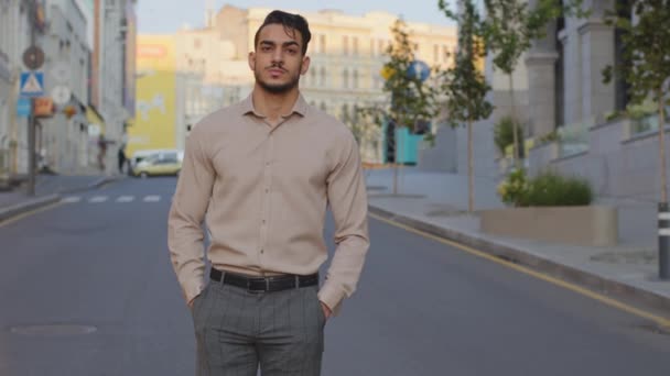 Komoly spanyol arab üzletember sétál formális ruhában, közel a modern épület hátteréhez. Magabiztos, sikeres szakállas férfi sétál az utcán. Hndsome főnök menedzser megy ki a szabadba — Stock videók