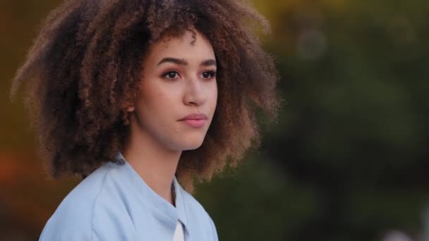 Close-up sério rosto feminino, retrato jovem bela mulher africana com penteado afro sentado ao ar livre olhando para a distância acena cabeça sim positivamente ondas não discordo muda de mente, menina emocional — Vídeo de Stock