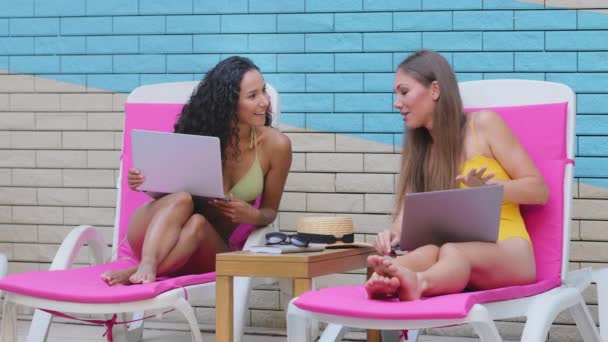 Diferentes etnias alegres jóvenes amigas dan alta cinco amigos gesto. Independiente hispano caucásico que usa computadoras portátiles junto a la piscina de verano del hotel. Saludo, celebrar felicitar gran concepto de noticias — Vídeo de stock