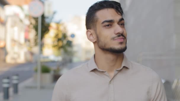 Homem de barba árabe headshot caminha na cidade. Um belo rosto masculino de perto. Homem de negócios hispânico movendo-se na rua perto do edifício do escritório da empresa. Retrato chefe líder profissional turista andando — Vídeo de Stock