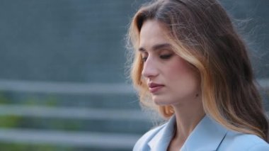 Mükemmel cilt makyajlı, yakın plan kadın portresi Kafkasyalı genç sarışın kız milenyum iş kadını başını çeviriyor ve şehirde baştan çıkarıcı bir ifadeyle kameraya bakıyor.