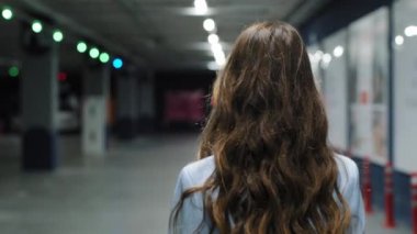 Sarışın, güzel, şık bir iş kadınının, kapalı bir alanda, ofis şirketinin içinde yürürken ciddi bir ifadeyle kameraya bakışının, yakın plan kadın patron portresinin.