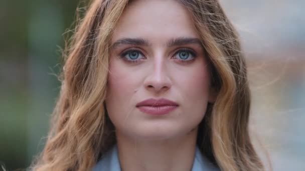 Extrém közelkép nő komoly arc természetes smink kék szeme nézi kamera pózol a szabadban. A fiatal kaukázusi Y-generációs üzletasszony modell szőke lány bámul. Portré 30-as hölgy odakint. — Stock videók