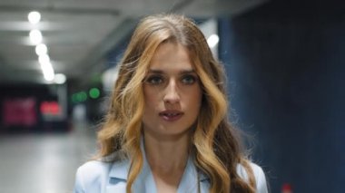 Ciddi bir portre genç, bin yıllık iş kadını patron kızgın, iki yüzlü, odaklanmış, kararlı, kararlı kadın ofisteki kapalı otoparkta dikiliyor.