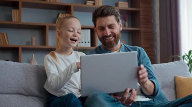 Neşeli Kafkas ailesi gülen baba ve küçük kız dizüstü bilgisayara gülüyorlar mutlu, sevimli çocuk kız ve babası bilgisayarlı komik videolar izliyorlar.