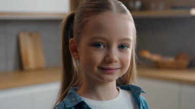 Kapalı portre, beyaz mutlu küçük kız gülümsüyor. Mutfak kamerasına bakıyor. Aile içi ilişkilerde iyi velayet.