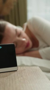 Kafkasyalı bir kadın sabah uyandığında çalar saatle uyanıyor kızgın yorgun kız yeni bir gün evde uyanıyor yatak odasında uykusuzluk çekiyor yüksek sesli bir ses çınlayan kadın cihaz sağlığını bozuyor.