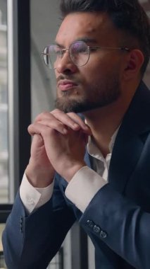 Düşünceli Hindu iş adamı ciddi iş adamı laptopla düşünen bin yıllık profesyonel erkek masa başı beyin fırtınasında bilgisayar görevinde düşünen adam ofiste ilham aramaya karar verdi.