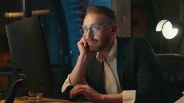 Yorgun iş adamı tembel, bilgisayar ekranına bakıyor, akşam ofisinde motivasyonsuz iş adamı internet üzerinden çalışıyor, yorgun erkek ajan geç saatlerde çok çalışıyor, Kafkas işçisi.