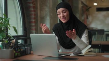 Arap Müslüman iş kadını kadın başörtülü kız lider online iş görüşmesi şirket video görüşmesi ofis bilgisayarında gülümseyen islami çalışanla uzaktan sohbet