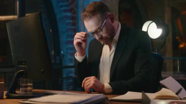 Kafkasyalı iş adamı bilgisayardan bıktı. Gece ofiste göz ağrısı çekiyor. İş adamı, göz rahatsızlığı çekiyor.