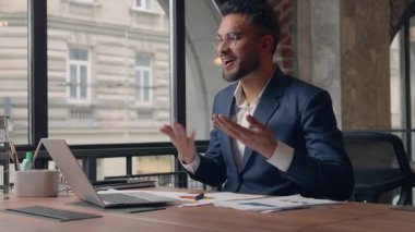 Hintli İspanyol iş adamı karşılama konferansı, sanal görüşme, kurumsal sohbet, gülümseyen Arap adam, elinde dizüstü bilgisayarı olan ve ofiste kağıt diyagramı tutan adam.