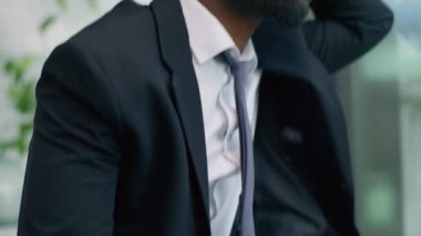 Çok çalışan Afrikalı Amerikalı iş adamı pencereden dışarı bakıyor. Sorunlu işadamı için endişeleniyor. Kendini kötü hissediyor.